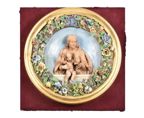 AN ITALIAN GLAZED AND BISCUIT POTTERY RELIEF MOULDED ROUNDEL IN THE DELLA ROBBIA STYLELATE 19TH CENTURYModelled with the Virg