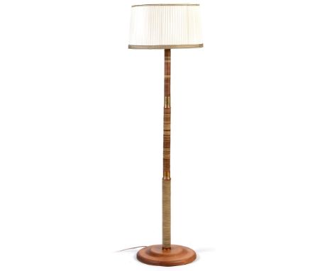 An Art Deco standard lamp , with a cream and pleated shade above a central column, constructed from disks taken from the page