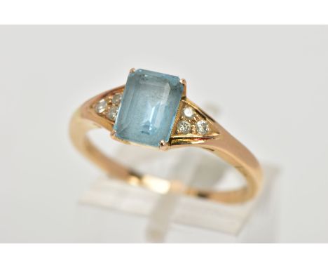 A YELLOW METAL GEM SET RING, designed with a central rectangular cut aquamarine in a four claw setting, flanked with three ro