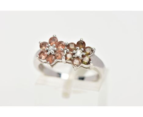 A 9CT WHITE GOLD GEM SET CLUSTER RING, a double flower design set with twelve circular cut stones assessed as topaz, prong se