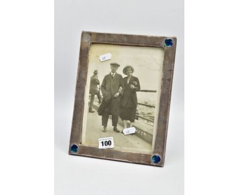 AN ARTS AND CRAFTS SILVER PHOTO FRAME, AF of a rectangular form, plain polished design with three corners set with a blue, gr