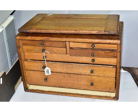 A VINTAGE OAK TOOL CHEST, carrying handle to the top, slide off front revealing an arrangement of two short and three long dr