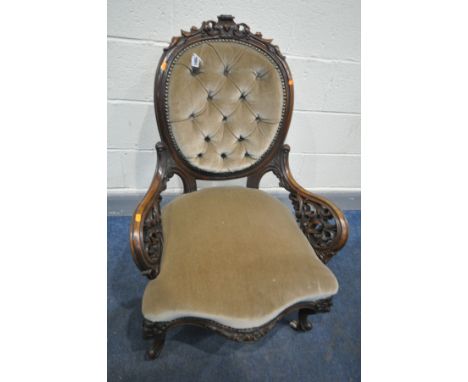 A VICTORIAN ROSEWOOD SPOON BACK ARMCHAIR, with an oval buttoned back, acanthus decoration including open fretwork armrests, o