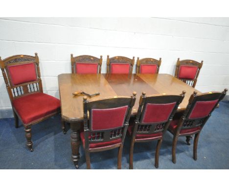 AN EDWARDIAN WALNUT WIND OUT DINING TABLE, with one additional leaf, on turned fluted legs, and ceramic casters, open length 