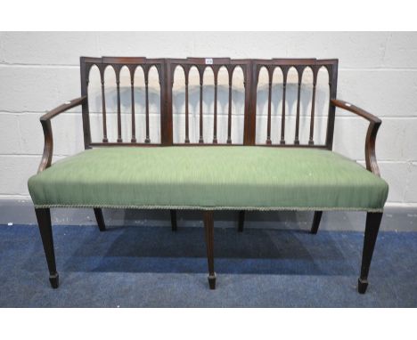 AN EARLY 20TH CENTURY MAHOGANY SOFA, with shaped spindled back, and open armrests, on square tapered front legs, length 126cm