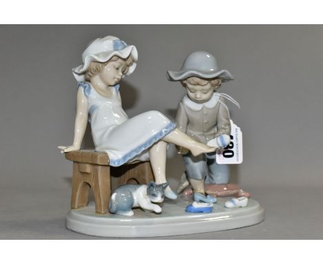 A LLADRO FIGURE GROUP 'TRY THIS ONE', NO. 5361, a boy and girl trying on shoes, designed by Regino Torrijos, issued 1986-1998