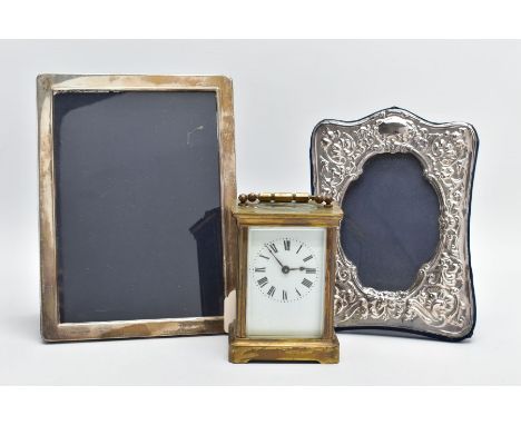 TWO SILVER PHOTO FRAMES AND A CARRIAGE CLOCK, the first frame featuring a floral design and an oval space for a photo, approx