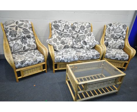 A WICKER FOUR PIECE CONSERVATORY SUITE, with floral cushions, comprising of a sofa, two armchairs and a coffee table