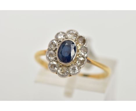 A SAPPHIRE AND DIAMOND RING, an oval cut sapphire bezel set with ten round brilliant cut diamonds, approximate total diamond 