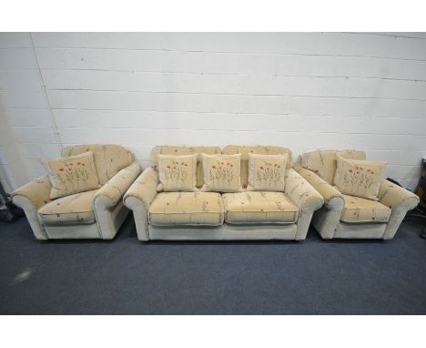 A FLORAL BEIGE UPHOLSTERED THREE PIECE SUITE, comprising a three seater sofa, length 200cm, and a pair of armchairs