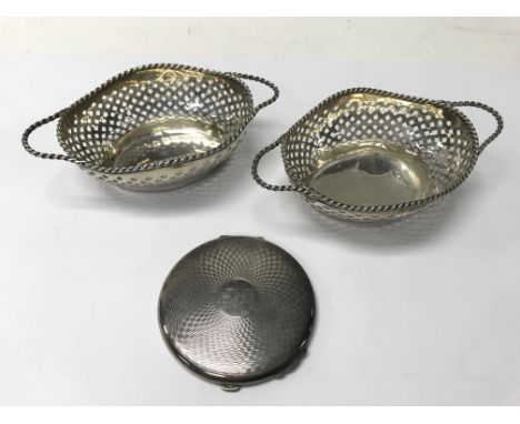 A pair of silver dishes (weight approx 82.54g) together with a silver compact.