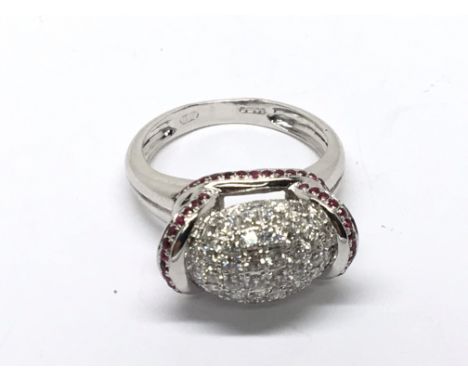 A decorative 9carat diamond and Ruby white gold ring set with a central cluster of diamonds Ring Size N.