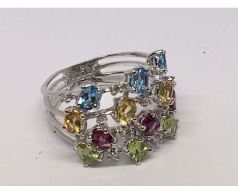 A white gold ring set with multi coloured stones. Ring size K.