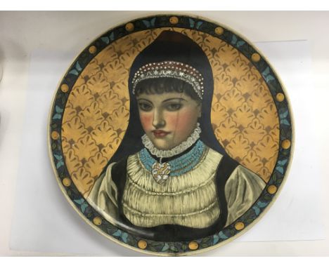 A large ceramic charger depicting a portrait of a lady surrounded by a border decorated with butterflies and fruit, signed by