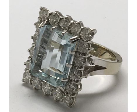 An impressive 18ct white gold  square cut ring set with an aquamarine, ( app 13x8mm),  surrounded by eighteen diamonds, appro