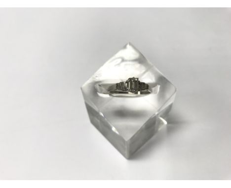 A platinum and diamond ring set with baguette diamonds (chip of central stone). Size approx R, weight approx 4g.