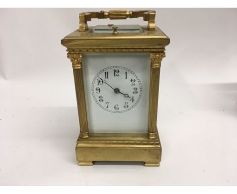 A French brass carriage clock with repeat alarm and visible escapement the enamel dial with Arabic numerals