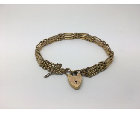 A gold tone gate bracelet and a necklace.