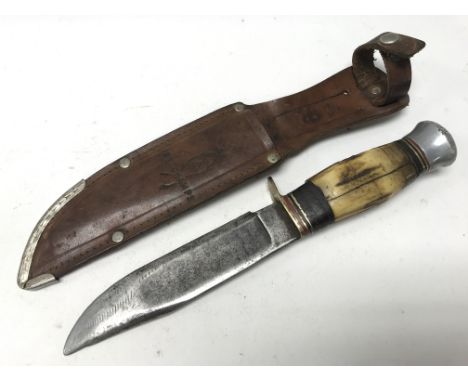 A vintage knife with horn and metal handle in leather sheath embossed with 'Belchamps'.