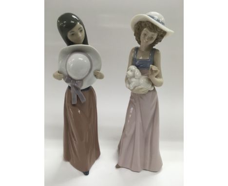 A Lladro figure of a girl holding a wide brimmed hat plus a Nao figure of a girl holding a puppy (2).