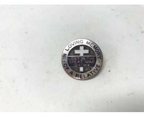 An enamel suffragette badge commemorating a lost relative from WW1.