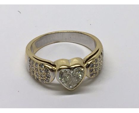 A Quality one carat heart shaped diamond ring set in 18 carat yellow gold with further rows of  diamonds.