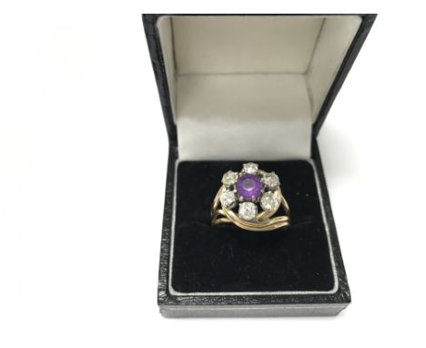 A ring set with central amethyst with six old cut diamonds in unmarked yellow gold. Weight approx 8.10g, size approx S/T.