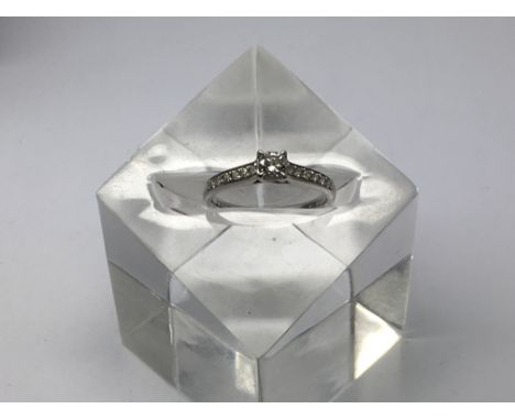 A brilliant cut diamond solitaire ring with diamond set shoulders, total carat weight 0.37, clarity SI1, colour G, approx 3g 