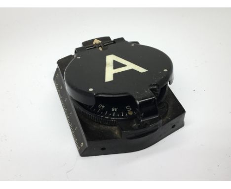 A Military Compass made of painted metal and black Bakelite.