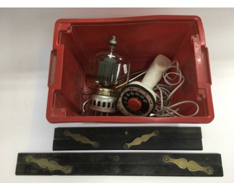A box of odds including two architectural drawing tools, a large valve, surgeon's tools and a vintage telephone.