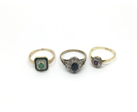 Thee rings including a 9ct diamond and sapphire ring, a 14ct diamond and emerald ring and a diamond and ruby ring