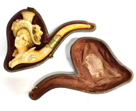 A MEERSCHAUM PIPE  carved in the form of a lady with an ornate feathered hat smoking a pipe, with an amber mouthpiece, 13cm l