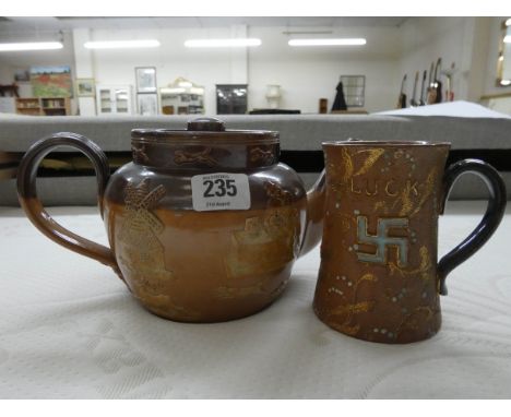 A Royal Doulton stoneware teapot and a Royal Doulton 'Good Luck' Swastika embossed mug