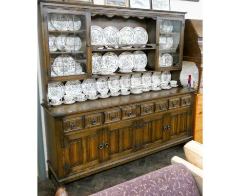 A very large reproduction oak linen fold panel carved dresser with leaded glazed panels above  