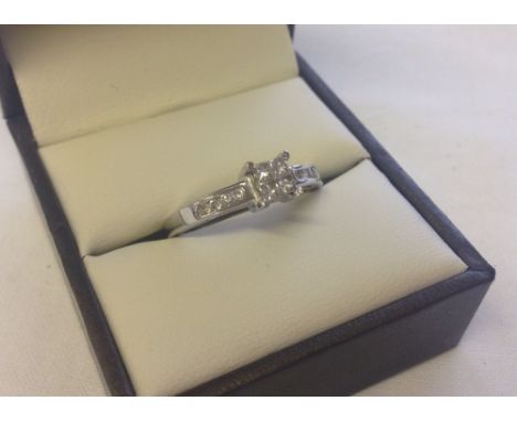 An 18ct white gold diamond ring set with 4 square cut diamonds set in square mount with 4 round cut diamonds channel set on e