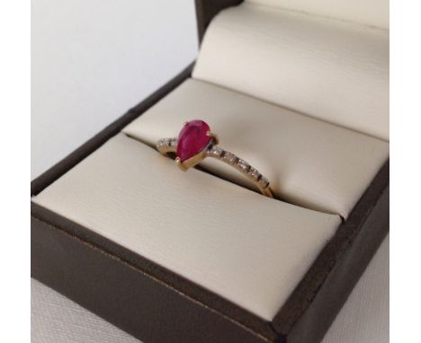 Ladies hallmarked 9ct gold dress ring set with a pear cut ruby 0.4ct with 5 diamonds either side. Size N, weight approx 1.8g