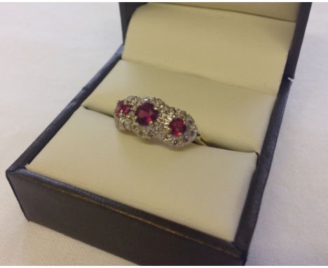 An 18ct gold, ruby and diamond triple cluster ring, size N.