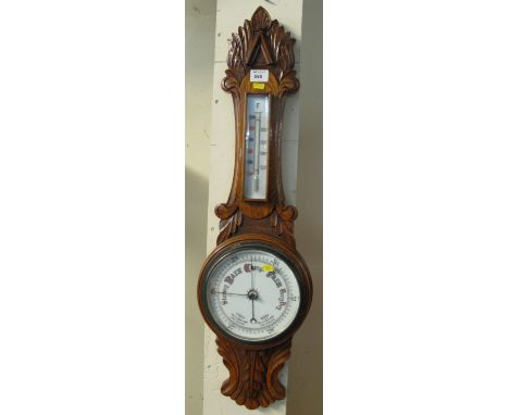 Early 20th Century oak foliate carved enamelled Aneroid barometer.