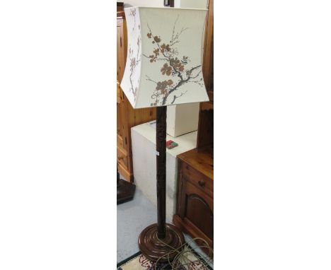 Stained hardwood standard lamp on stepped circular base, decorated in carved oriental taste.