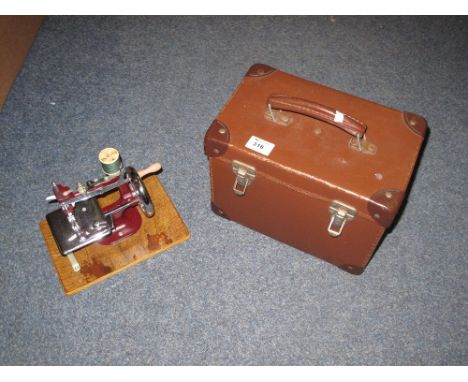 The Essex miniature sewing machine in a fitted case with instruction manual and carrying handle.