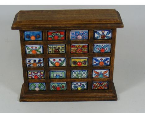 A Decorative Wooden Spice Rack With Ceramic Drawers