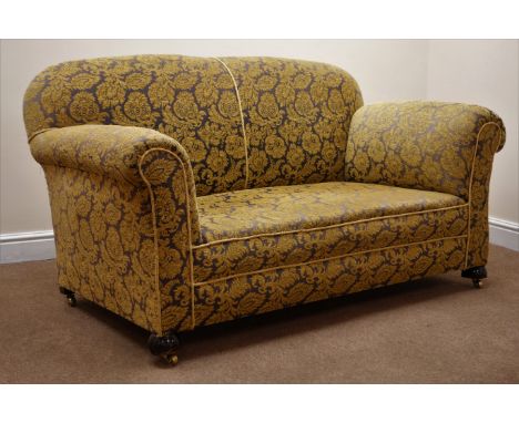 Victorian two seat drop arm sofa, upholstered in floral patterned gold and gun metal coloured fabric, turned supports on bras