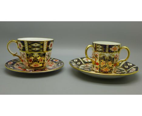 Two Royal Crown Derby Imari cups and saucers, one with three handles 