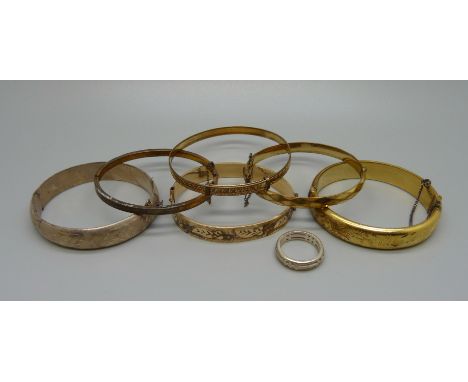 Four rolled gold bangles, a silver bangle, a silver ring and one other plated bangle 