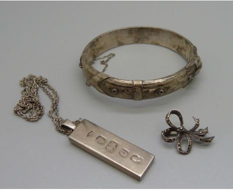 A silver bangle, a silver ingot pendant on chain and a silver brooch, 60g 