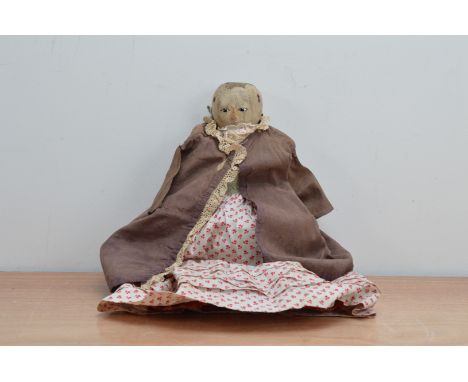 CHANGE OF DESCRIPTIONAn English George III turned and painted wooden doll, with inset enamel eyes, remains of dotted eyebrows