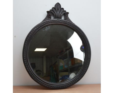A 20th century hard wood circular mirror, with a scrolling pediment, total height 74cm  