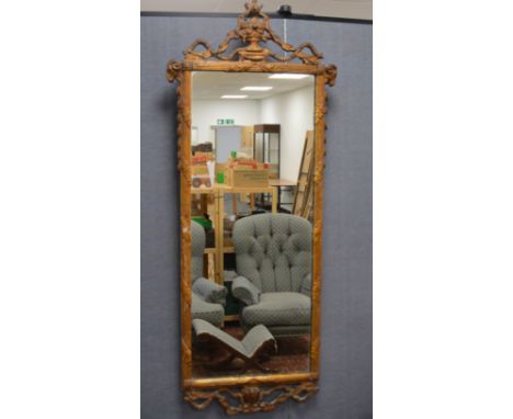 A Georgian long gesso framed mirror, mounted and surmounted with rams head and scroll work, replacement mirror plate, wear to