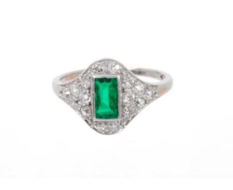 Art Deco emerald and diamond ring with a central rectangular step cut emerald estimated to weigh approximately 0.40cts surrou