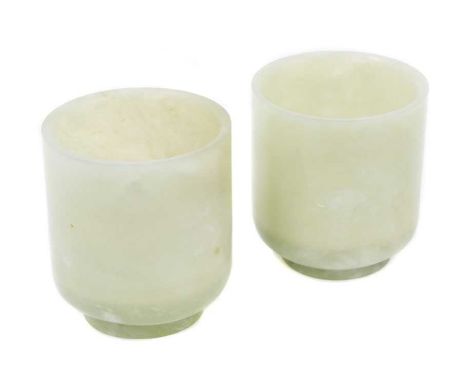 Two old Chinese green jade cups of cylindrical form raised on circular foot with dished bases 5.8cm high. Provenance: Purchas
